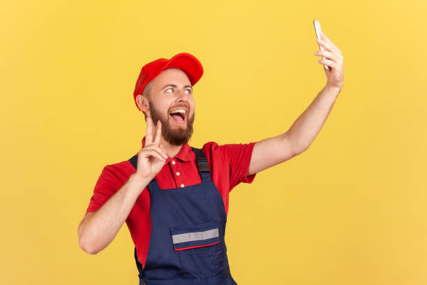 istock Worker taking selfie or talking on video call, looking playfully at device camera and showing v sign 1454209151