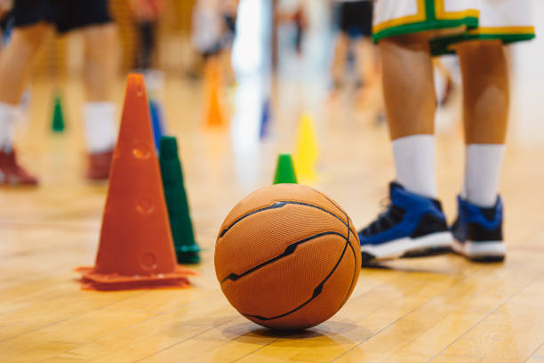 istock Junior basketball training. Boys practicing basketball on training session. Basketball on wooden floor on court 1454209448
