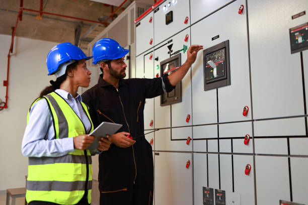 ingeniero eléctrico de colegas masculinos y femeninos trabajando en la sala de control de distribución eléctrica - fire power fotografías e imágenes de stock