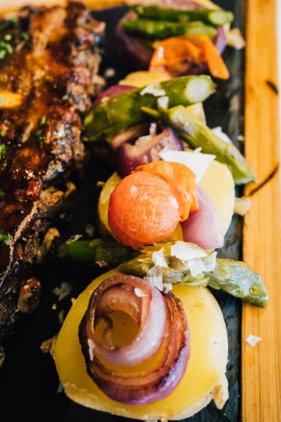 крупным планом жареный картофель и овощи, сопровождающие мед барбекю свиные ребрышки - barbecue beef close up multi colored стоковые фото и изображения