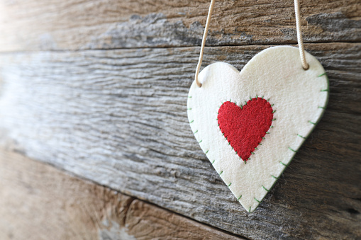 Fabric heart hanging on wooden surface