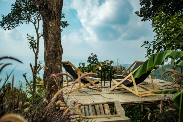 leerer entspannungssessel auf bambusplattform im berggipfelwald - campingstuhl stock-fotos und bilder