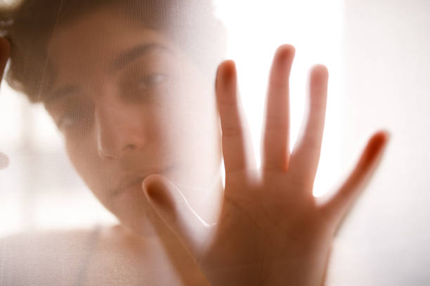 istock Woman looking through a sheer fabric while her hand touches it 1454221811