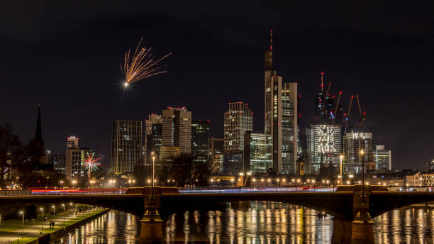 フランクフルトのスカイラインの上に花火が打ち上げられた大晦日 – 冬の寒い日の夜にメインで、水に色とりどりの反射があります。 - reflection new years day new years eve new year ストックフォトと画像