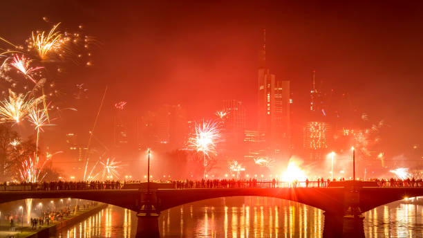 フランクフルトのスカイラインの上に花火が打ち上げられた大晦日 – 冬の寒い日の夜にメインで、水に色とりどりの反射があります。 - reflection new years day new years eve new year ストックフォトと画像