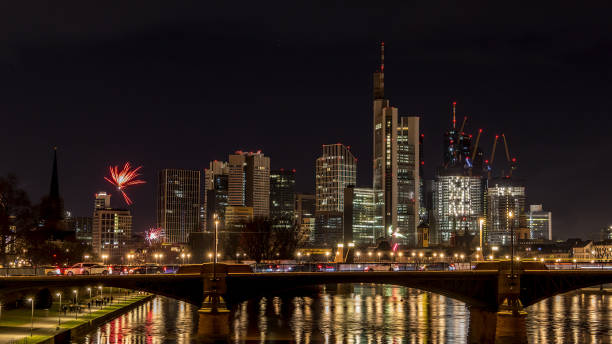 フランクフルトのスカイラインの上に花火が打ち上げられた大晦日 – 冬の寒い日の夜にメインで、水に色とりどりの反射があります。 - reflection new years day new years eve new year ストックフォトと画像