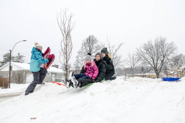 istock Kids and parents sliding on snow 1454227775