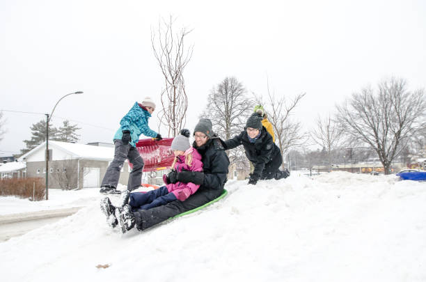 istock Kids and parents sliding on snow 1454227796