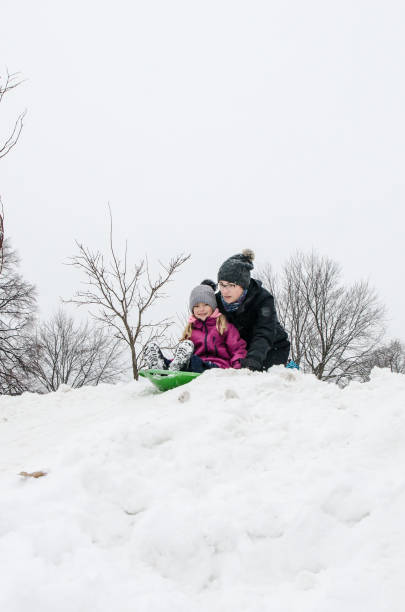 istock Kids and parents sliding on snow 1454228480