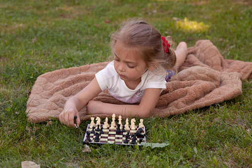 Child arranging chess pieces on the board