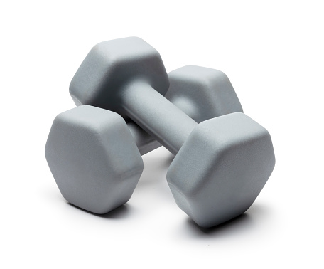 Two Dumbell weights stacked on Top of Each other on a White Background photographed in the studio with no people. This image would work well for new years resolutions, fitness and exercise