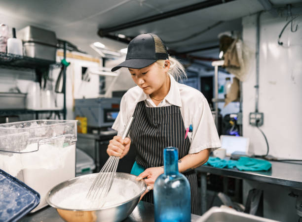 istock Young Korean female chef working in restaurant kitchen 1454233940