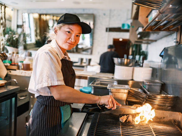 istock Young Korean female chef working in restaurant bar kitchen 1454234447