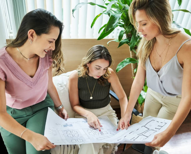 istock Group of interior designers discussing a blueprint at office 1454235769
