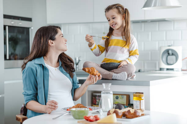istock Mother and her daughter having breakfast in the kitchen 1454236877