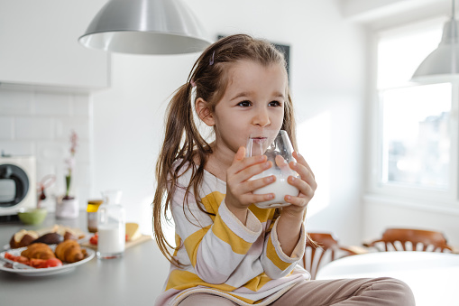 5 years old girl holding glass of milk