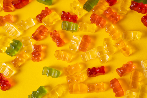 High angle view close-up of an assortment of colorful jellybeans, lollipops, candies and marshmallows.