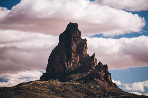 A stunning view of Shiprock, a majestic rock formation in New Mexico, under a clear blue sky.