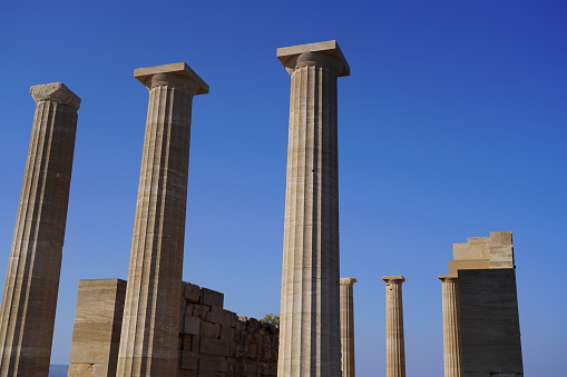 Fragment of a classical building with columns on a background of the blue sky with copy space