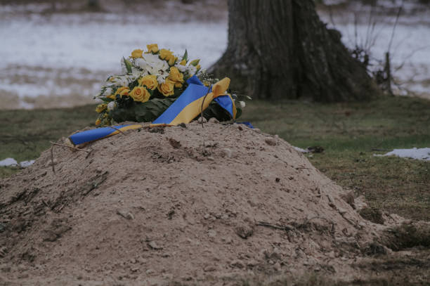 istock recently dug grave with burial ornament 1454241938