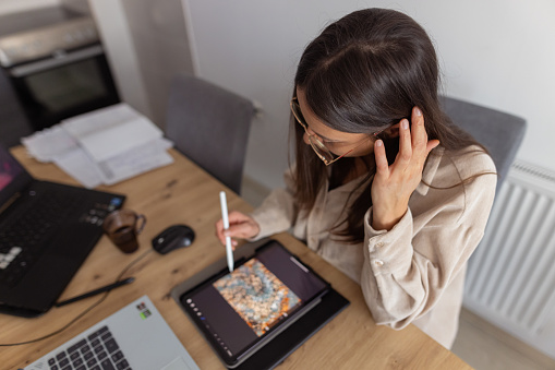 A shot of one graphic designer working at home office, drawing on a graphic tablet and making some abstract art.