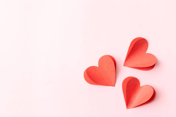 Valentine's Day background with red hearts on pink background stock photo