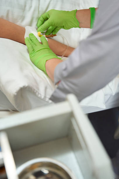istock Nurse uses plaster when fixing the needle on patient hand 1454245299