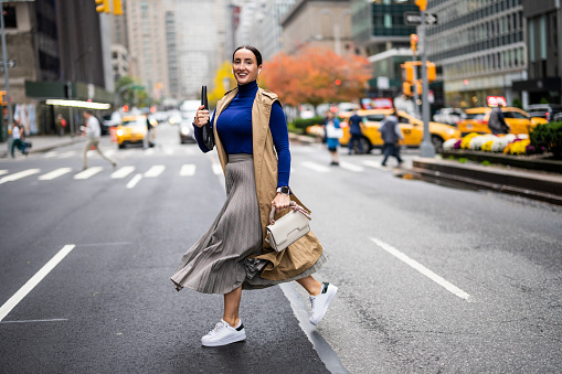 Una mujer vista cruzando la calle en Nueva York durante un ajetreado día de trabajo photo