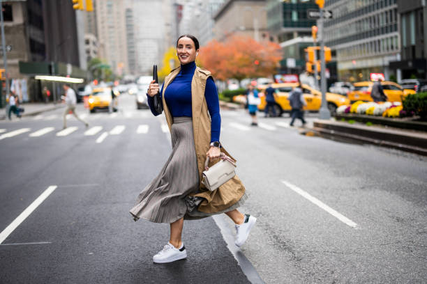 une femme vue traversant la rue à new york pendant une journée de travail bien remplie - headphones relaxation outdoors caucasian photos et images de collection