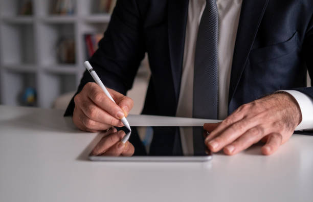 istock Businessman Signing Digital Contract On Tablet Using Stylus Pen 1454250064