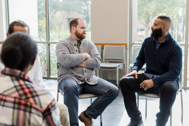 istock Men pair off in therapy to talk one-on-one 1454251294