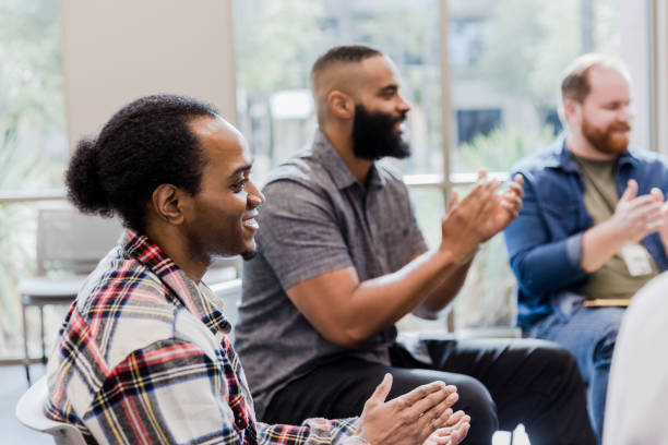 istock Diverse men applaud and encourage unseen group member 1454251323