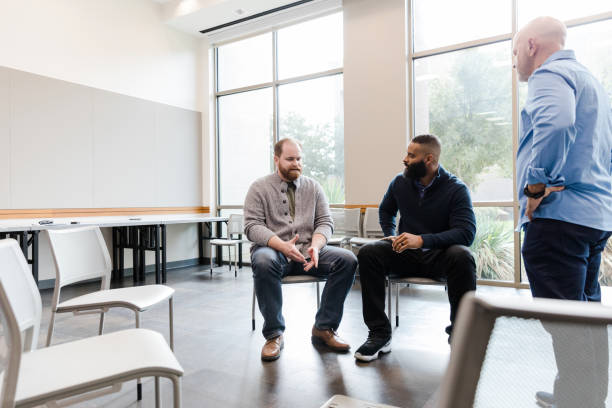 istock Mature male counselor mediates discussion between two men 1454251354