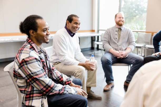istock Diverse men smile as unseen group member speaks 1454251360