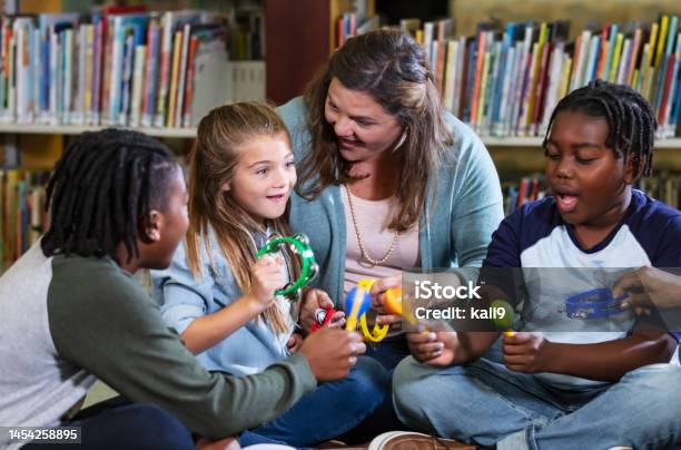 Woman And Children Making Music With Toy Instruments Stock Photo - Download Image Now