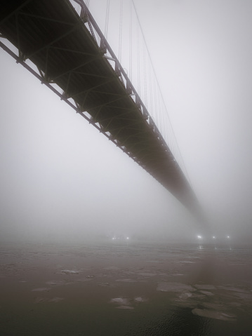 The Ambassador bridge links Detroit, Michigan with Windsor, Ontario.  It is one of the busiest trade routes in North America.  This photo was taken from Windsor, Ontario, Canada, during a foggy winter evening.