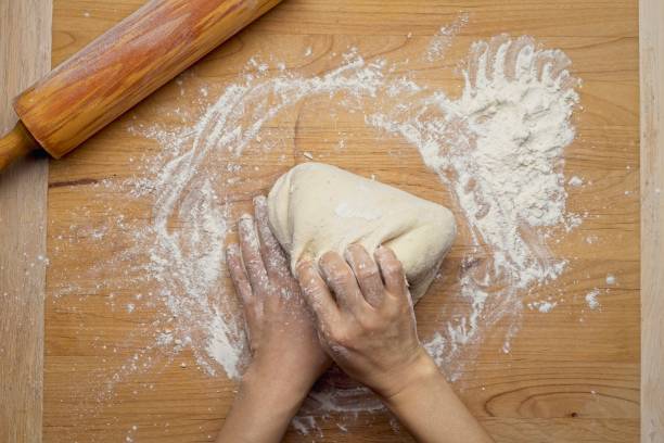 istock Top down view of pulling up dough to knead it. 1454261580