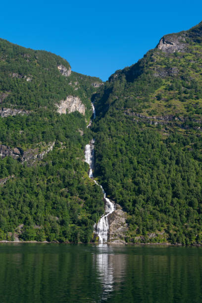 Water dropping down from the Bringefossen (a.k.a. Gomsdalsfossen) waterfall into the Geiranger Fjord stock photo