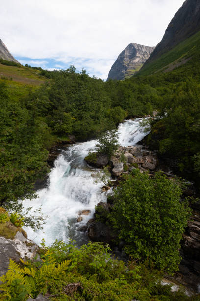 The impressive Storseterfossen (Storsæterfossen) with a path leading behind it throwing water down towards Geiranger stock photo