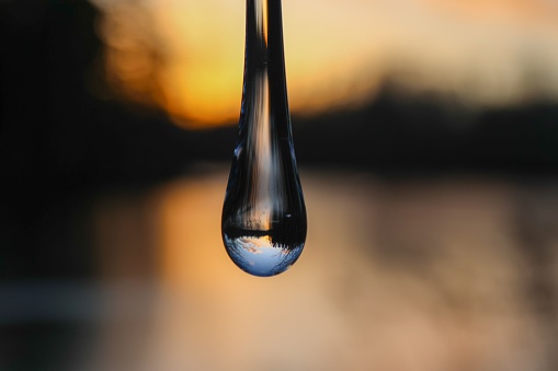 A soft focus of a water droplet with reflection of the sky