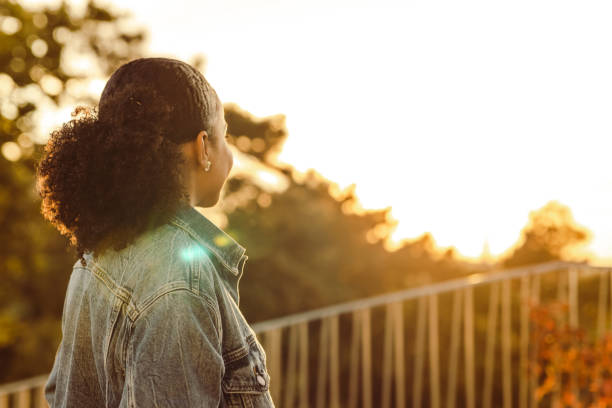 Rear view of a woman watching sunset and contemplating