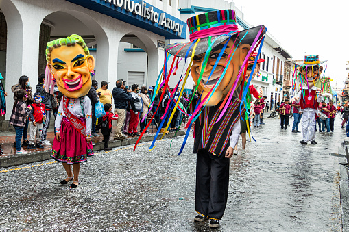 Cuenca, Ecuador - February 26, 2022: Parade during the carnival in the historic center of city Cuenca. Giant puppets in national costumes. Ecuador