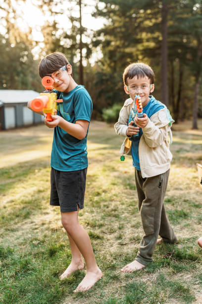 istock Brothers playing with toy gun in back yard 1454268915
