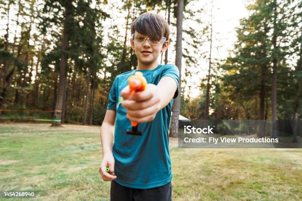 Tween Boy Aiming Toy Gun Toward Camera Stock Photo - Download Image Now - 12-13 Years, Active Lifestyle, Adventure