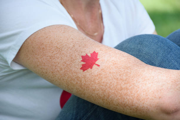 istock Red maple leaf tattoo on woman's arm on Canada Day 1454271533