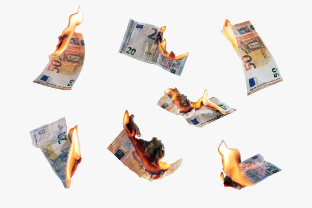Burning money, collection of twenty and fifty euro banknotes with flames isolated on a white background, finance concept for inflation, currency and investment risk, selected focus stock photo