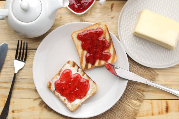 istock toasts with jam. fried crispy toast with red jam on a natural wooden table. breakfast. top view 1454276705