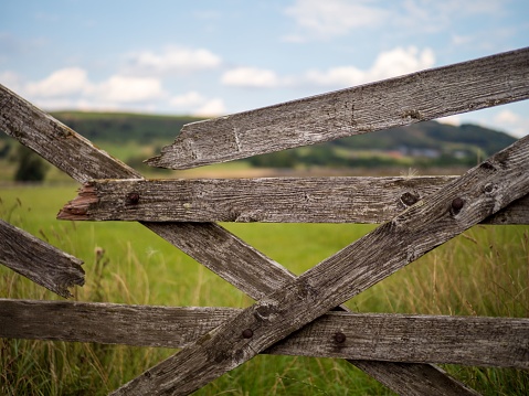 A wooden fence with a background of stone buildings in a countryside