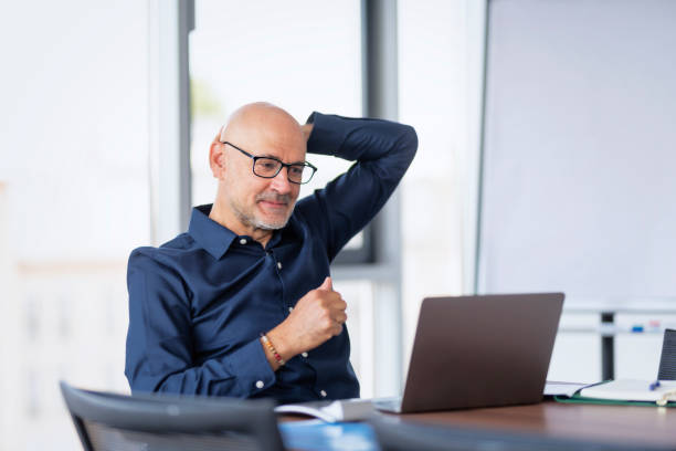 istock Confident businessman using laptop during online meeting with co-workers 1454287032