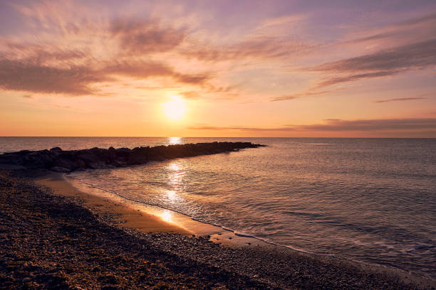 istock Silhouette of a child on a breakwater at dawn 1454287097